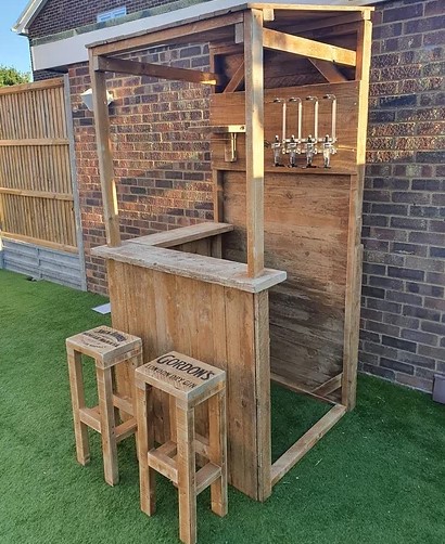 outdoor corner bar with food and bar stools in garden